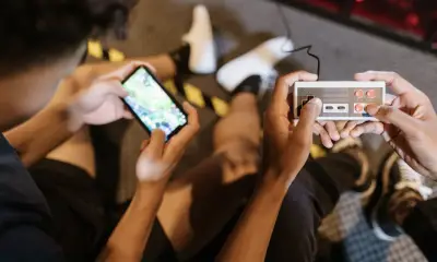 Two people playing on a phone and a vintage game